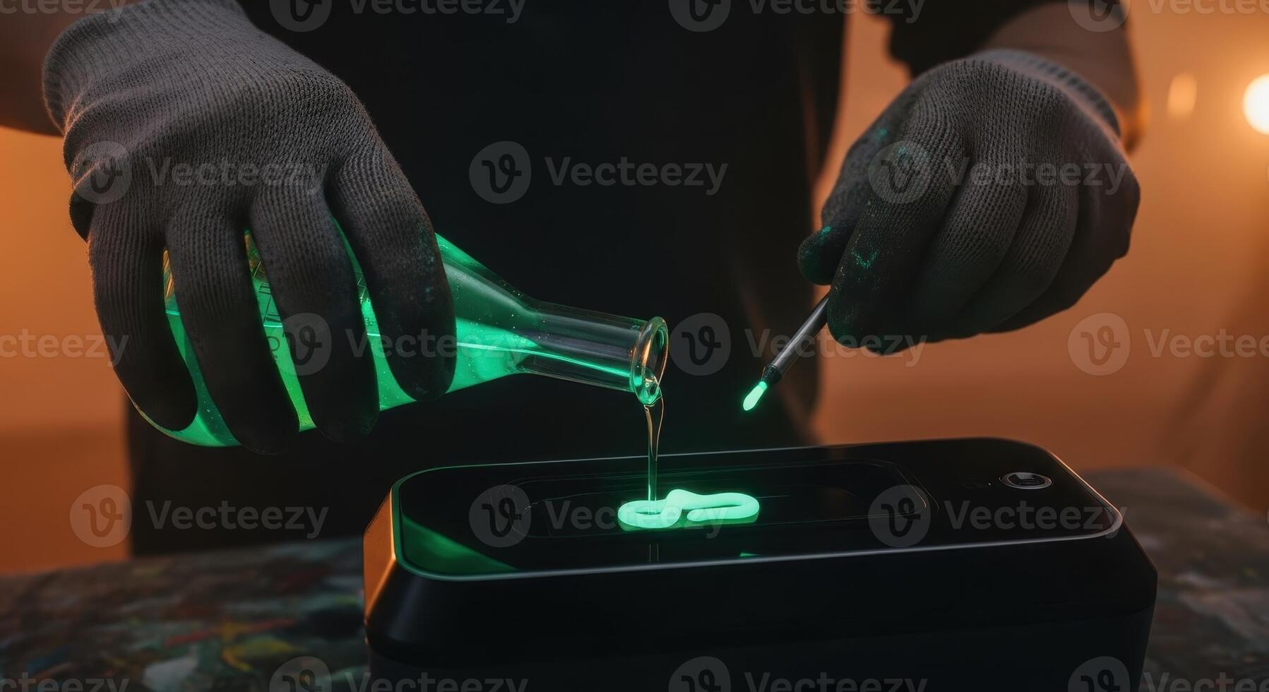 Gloved hand pouring glowing green liquid from a flask into a modern black device photo