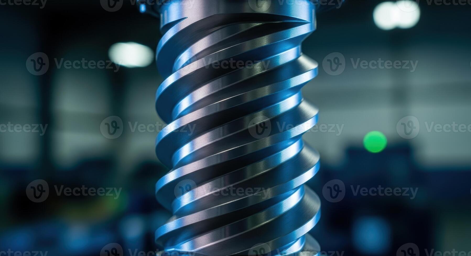 Close up of a shiny metallic screw thread from industrial machinery with blue light reflections photo