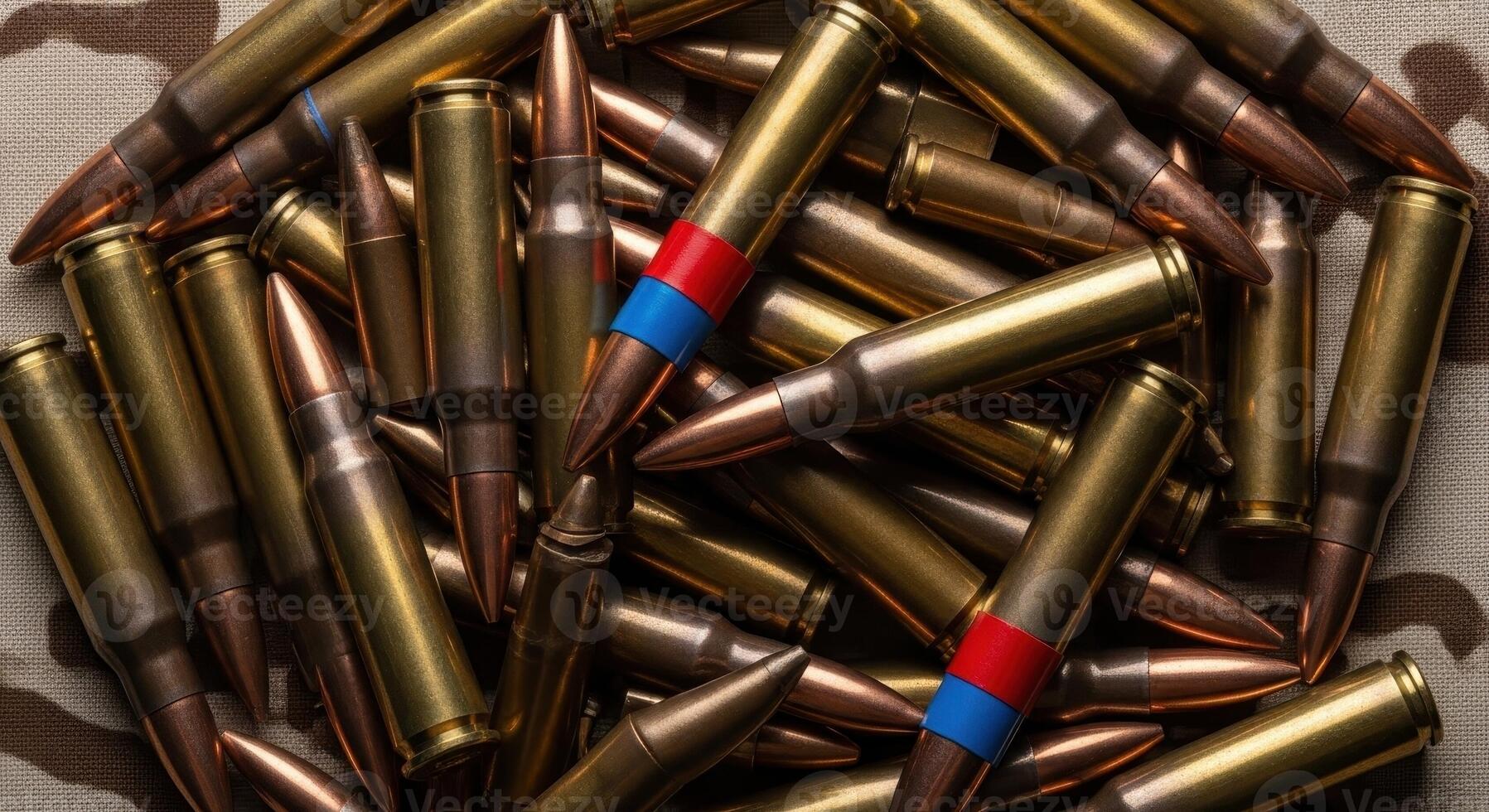 Pile of rifle cartridges with brass casings and copper projectiles on camouflage. photo