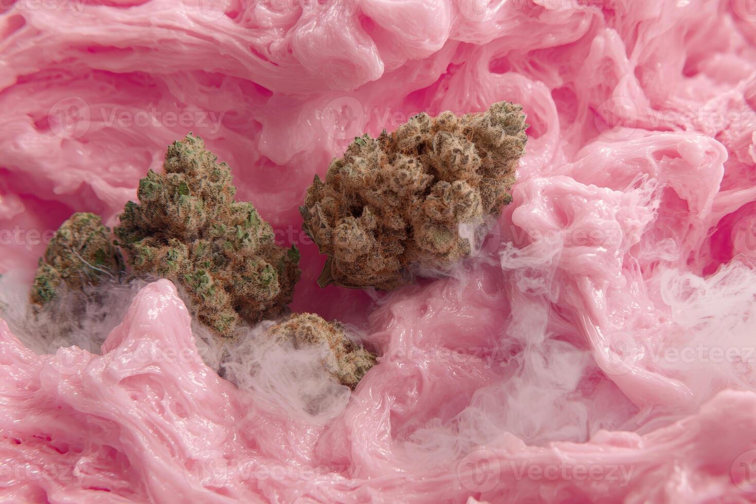 Cannabis buds resting in a bed of pink cotton candy photo
