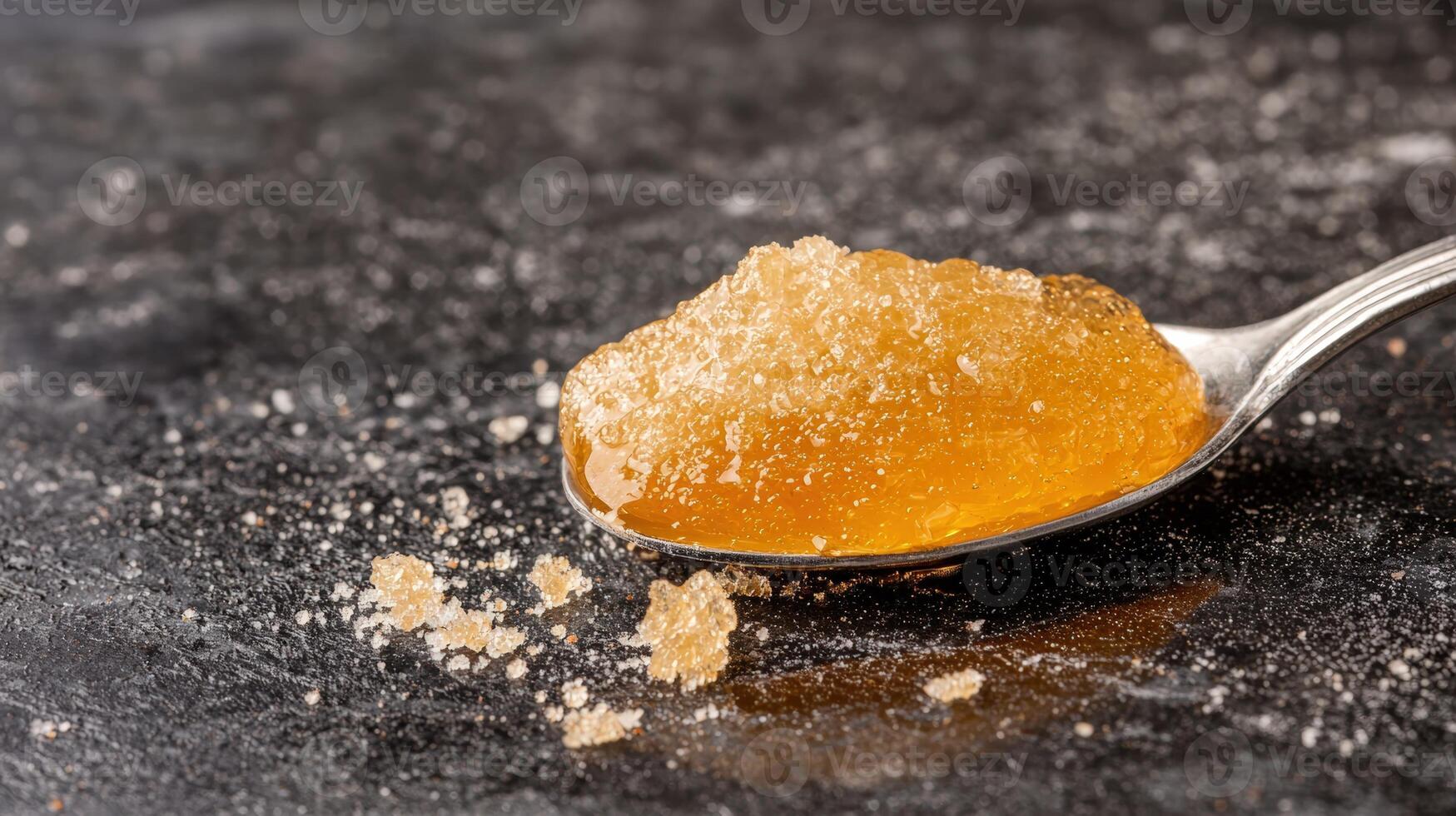 Spoonful of golden honey on a dark surface photo