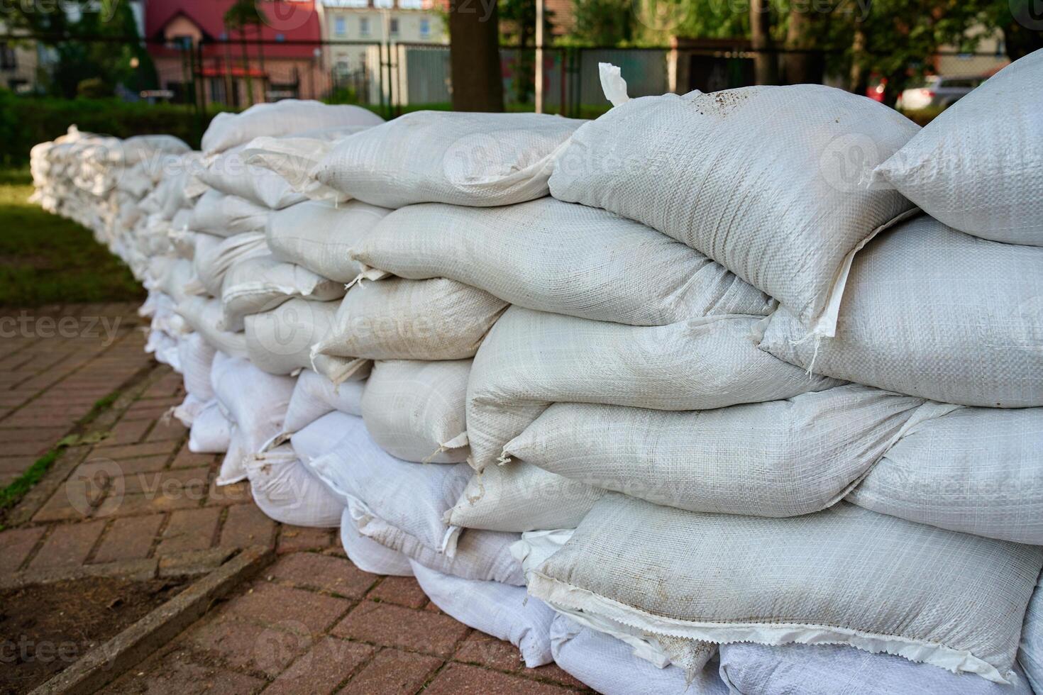Flood prevention wall made of white sandbags in city street photo