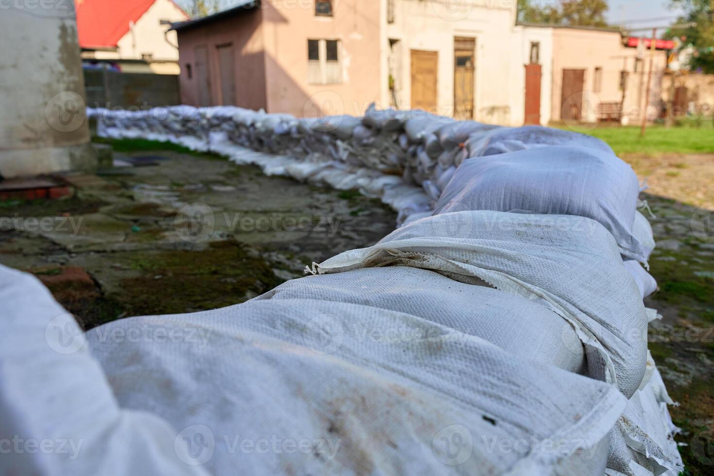 Sandbags stacked near house, protection from flood risk emergency photo