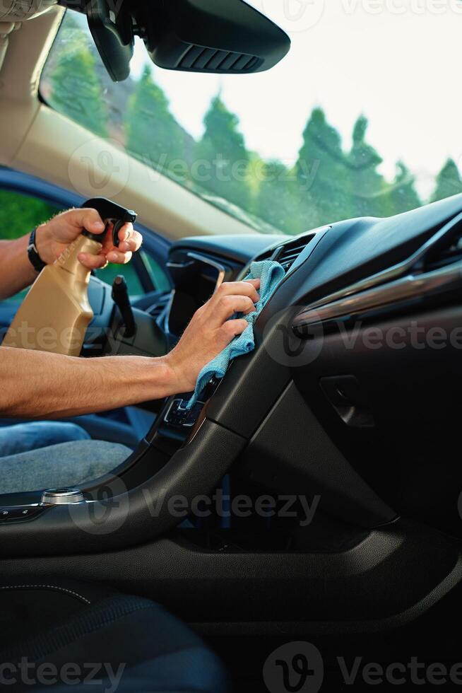 Cleaning Car Dashboard with Spray and Cloth photo