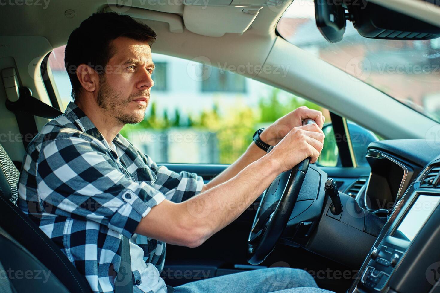 Man looking at rear view in modern car photo