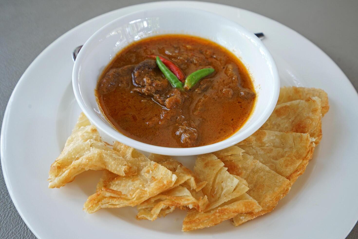Close up Stewed beef curry served with crispy Roti photo