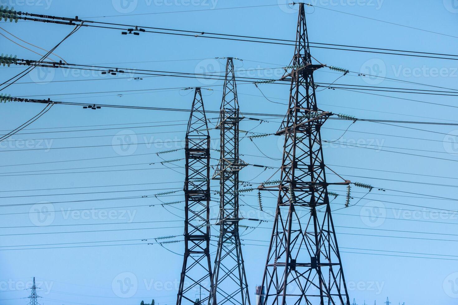 High voltage power lines and pylons against blue sky. Electric tower. Power transmission lines. Energy security and clean energy. photo
