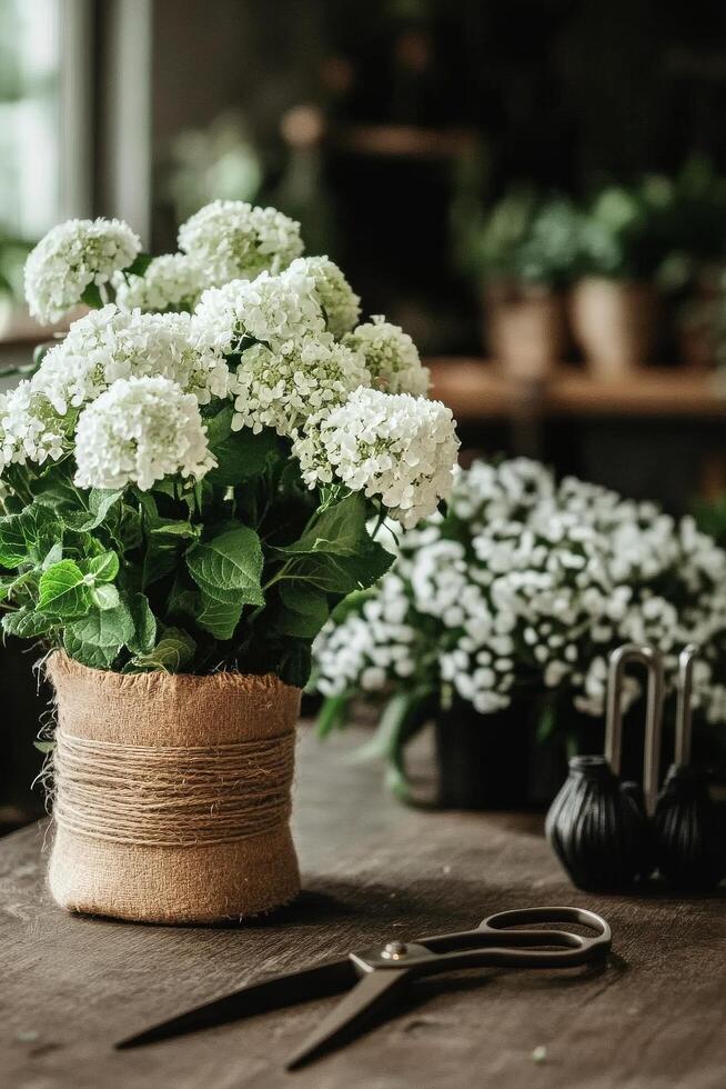 Floral Arrangement With White Blooms and Gardening Tools on a Rustic Wooden Table. photo