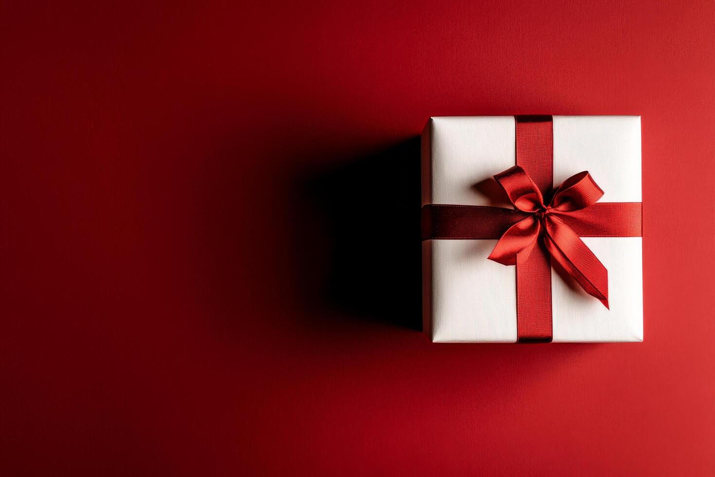 Gift Box With Red Ribbon on Festive Red Background, Perfect for Celebrations and Special Occasions photo
