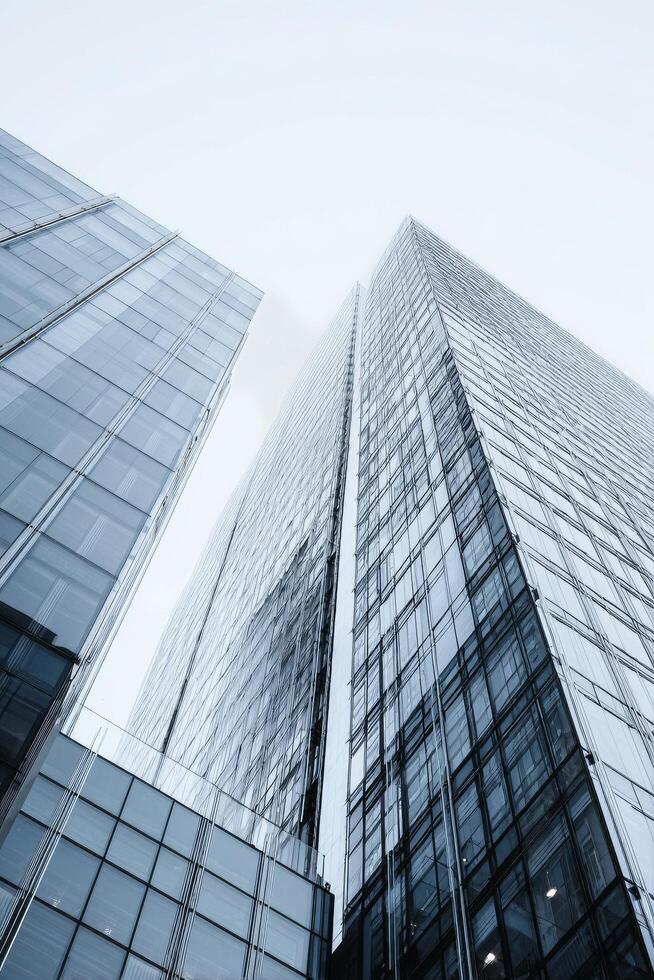 Skyscrapers Rising Towards a Cloudy Sky in an Urban Landscape With Glass Facades Reflecting Light photo