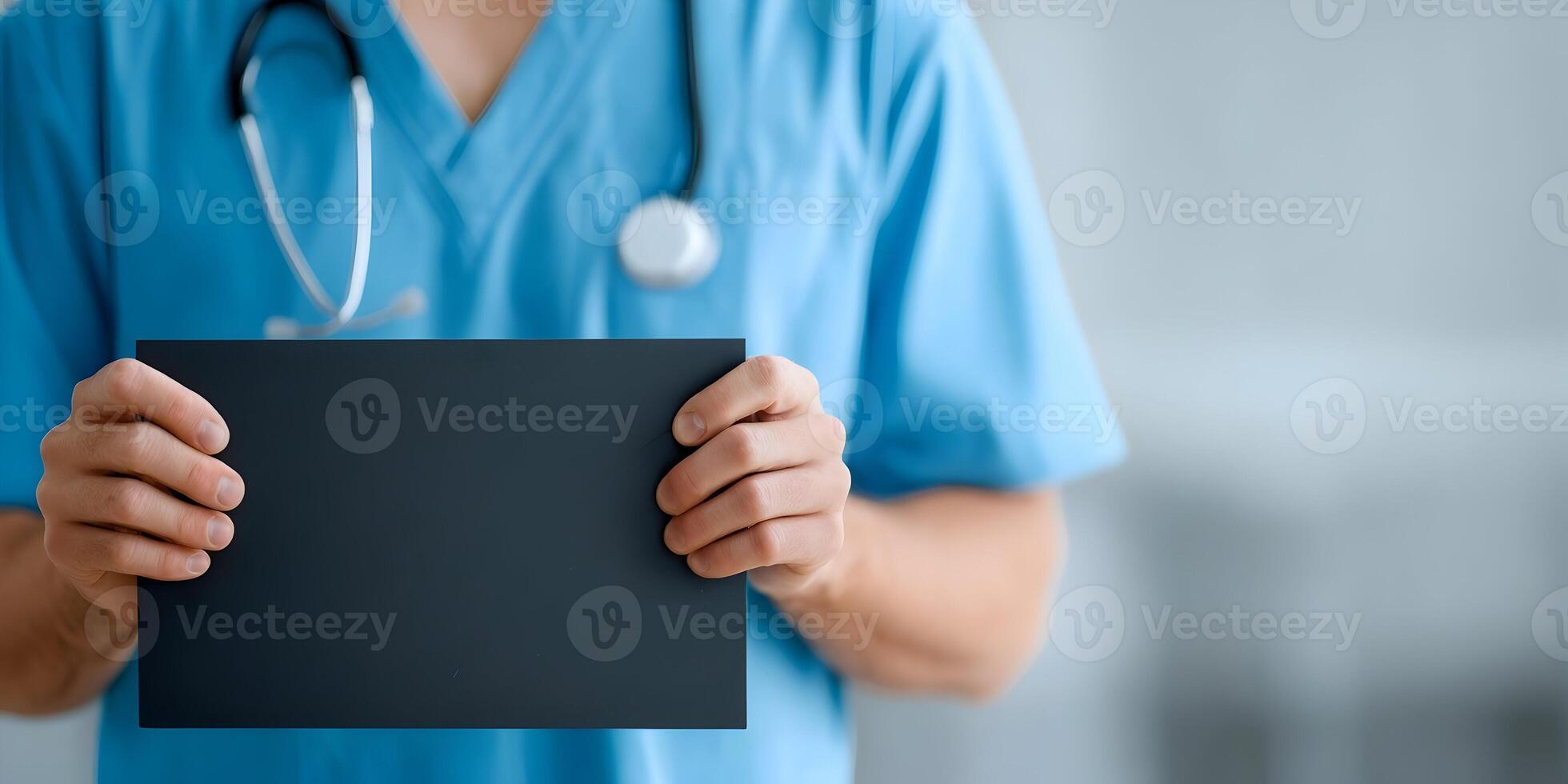 Male Doctor in Blue Scrubs Holding Blank Black Sign Medical Healthcare Announcement photo