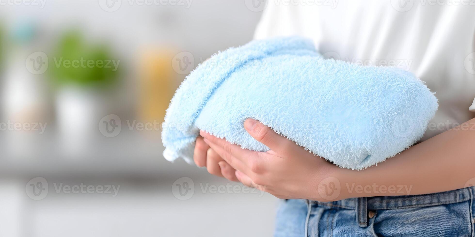 Woman Holding a Folded Light Blue Soft Towel Close Up photo