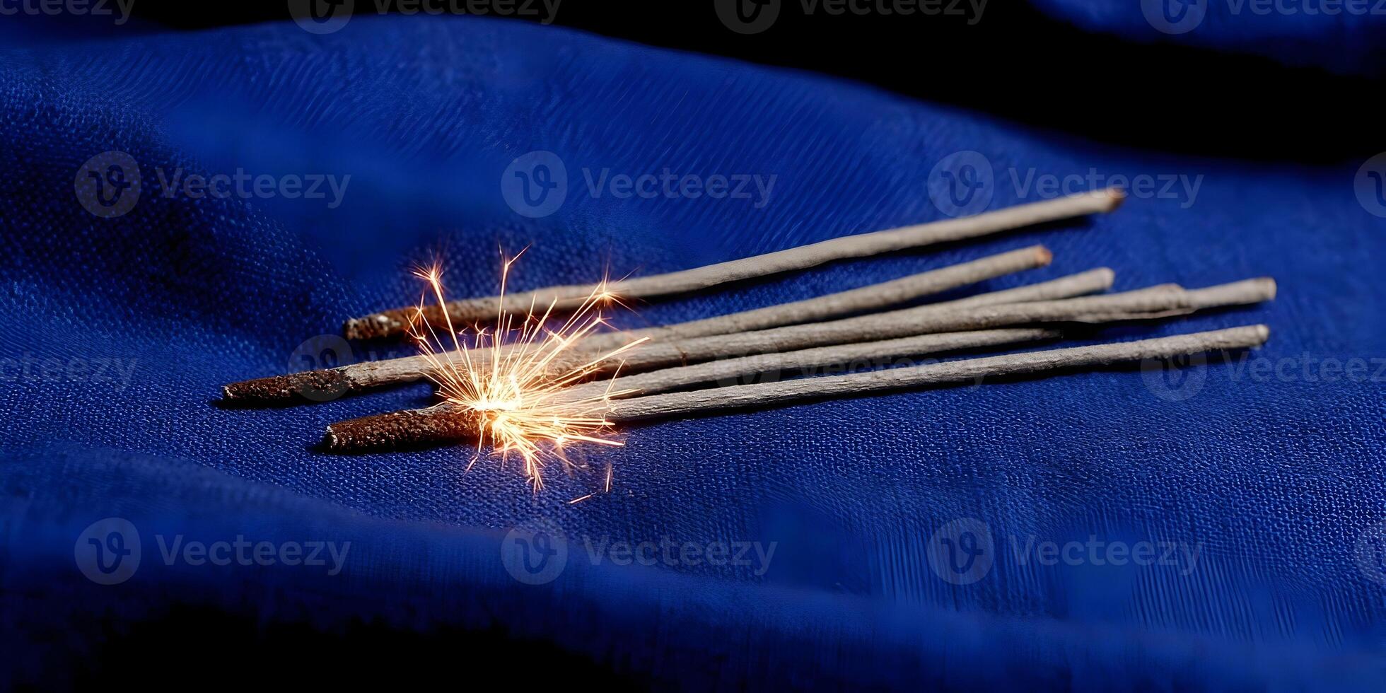 Burning Sparklers on Blue Fabric Background Festive Celebration New Year Party photo