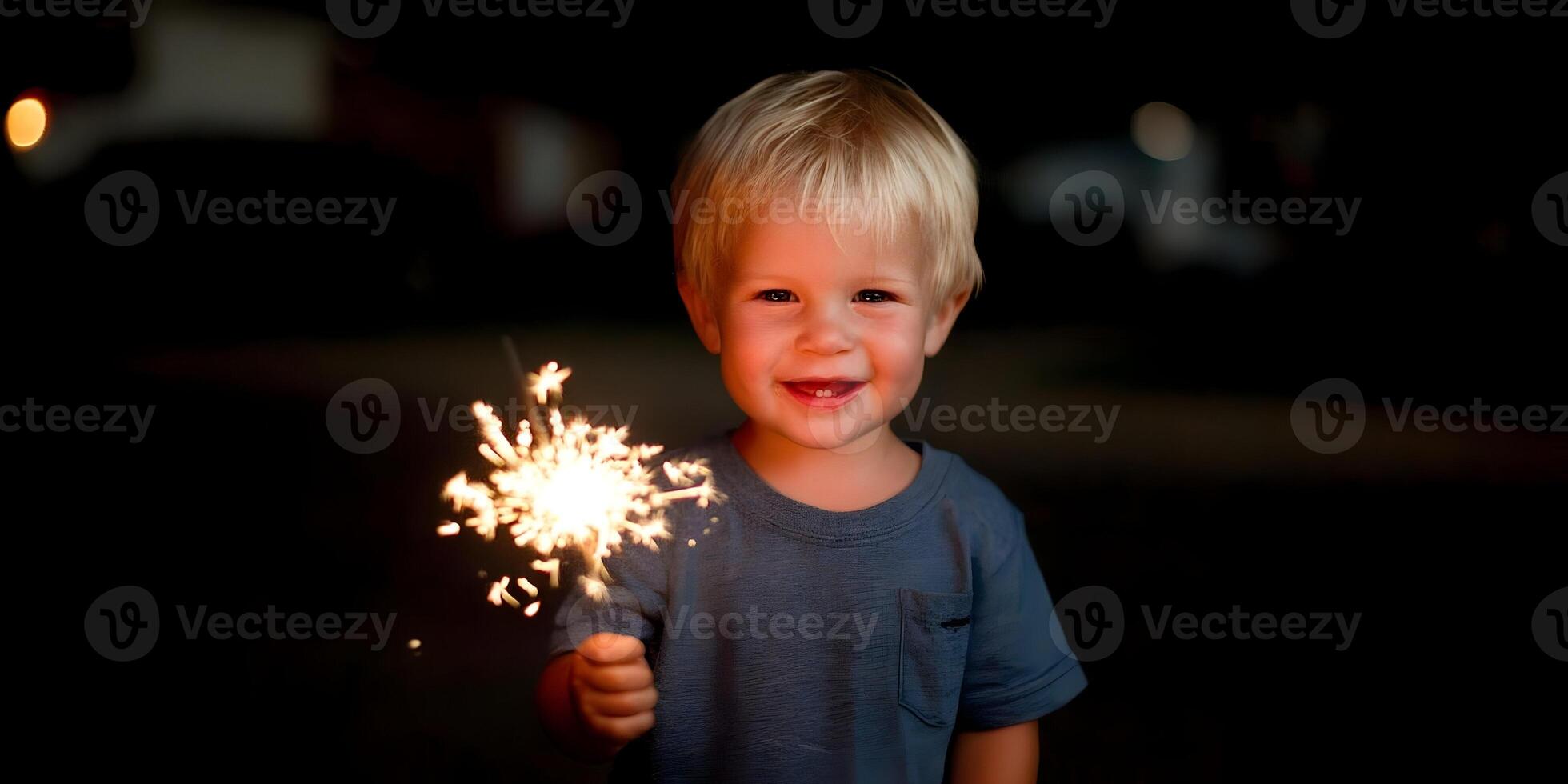 a young boy holding a sparkler in his hand photo