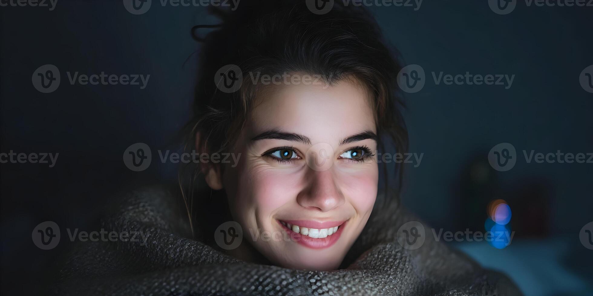 Smiling Woman Wrapped in Blanket at Night Using Tablet photo