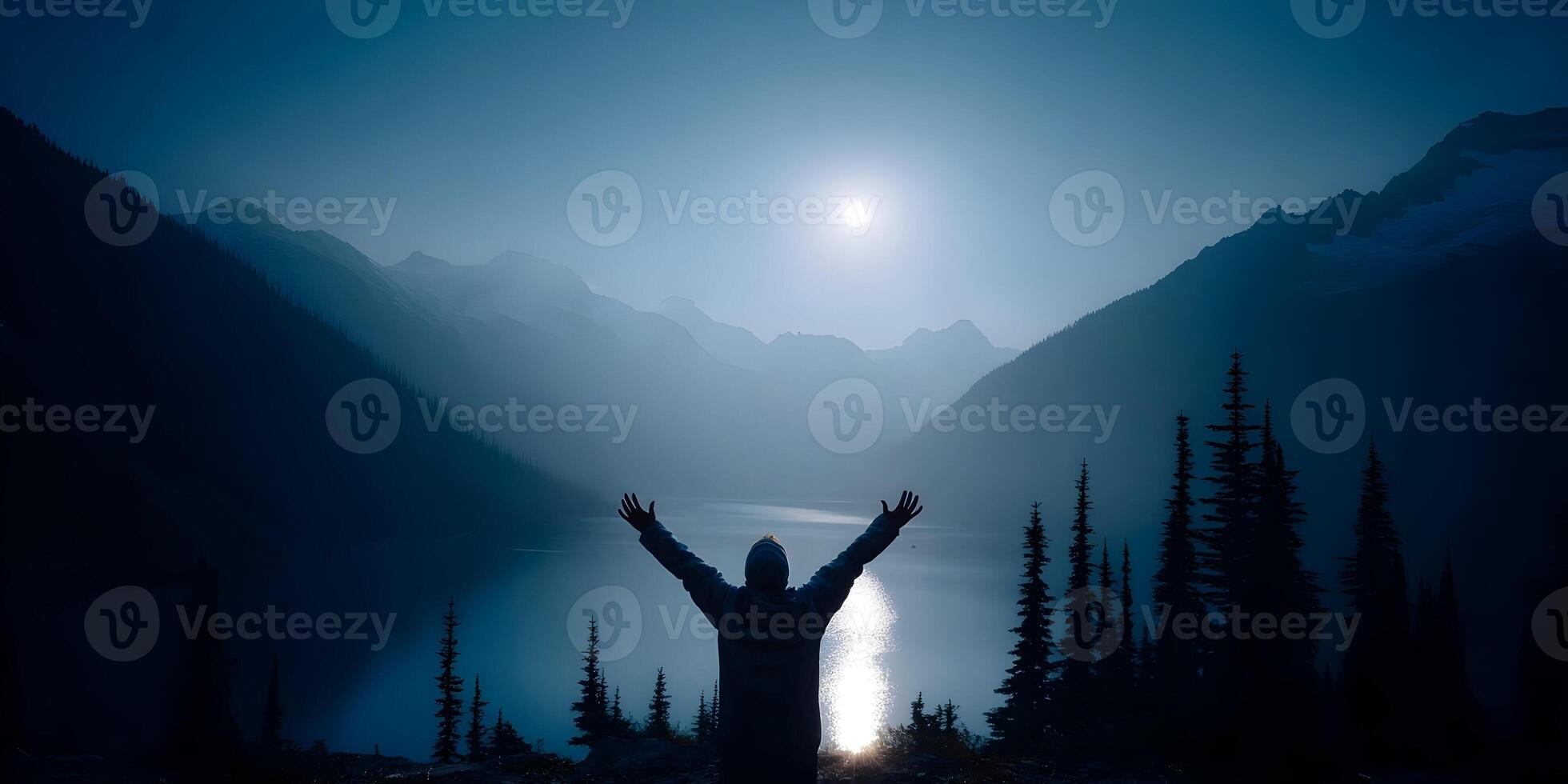 a person standing in front of a mountain lake with their arms outstretched photo