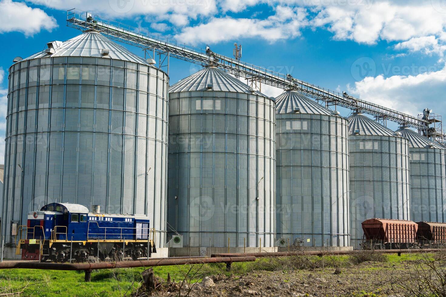 Agricultural silos for storage harvest at an agricultural production farm. Modern granary elevator. Loading and transportation of agricultural products by railway. Agribusiness photo
