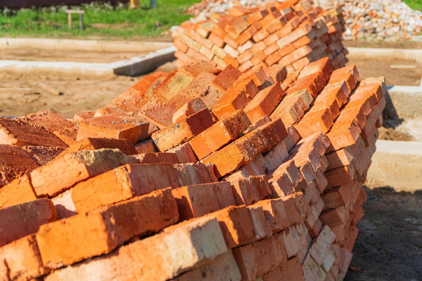 Red bricks stacked at a construction site. Construction of brick houses. Material for the construction of walls and partitions photo