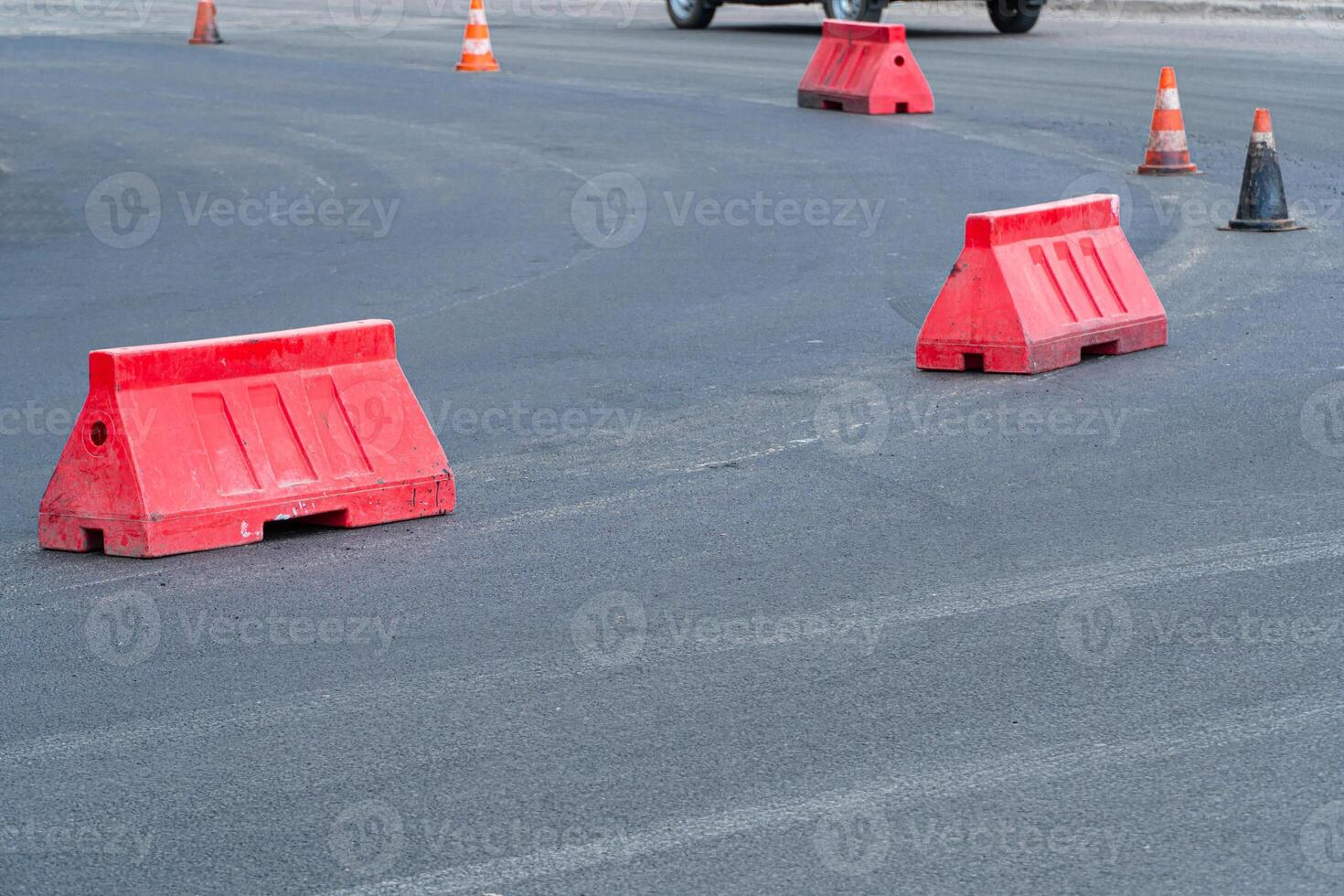 Repaving. New asphalt road. Plastic road fencing. Red barriers on the road photo