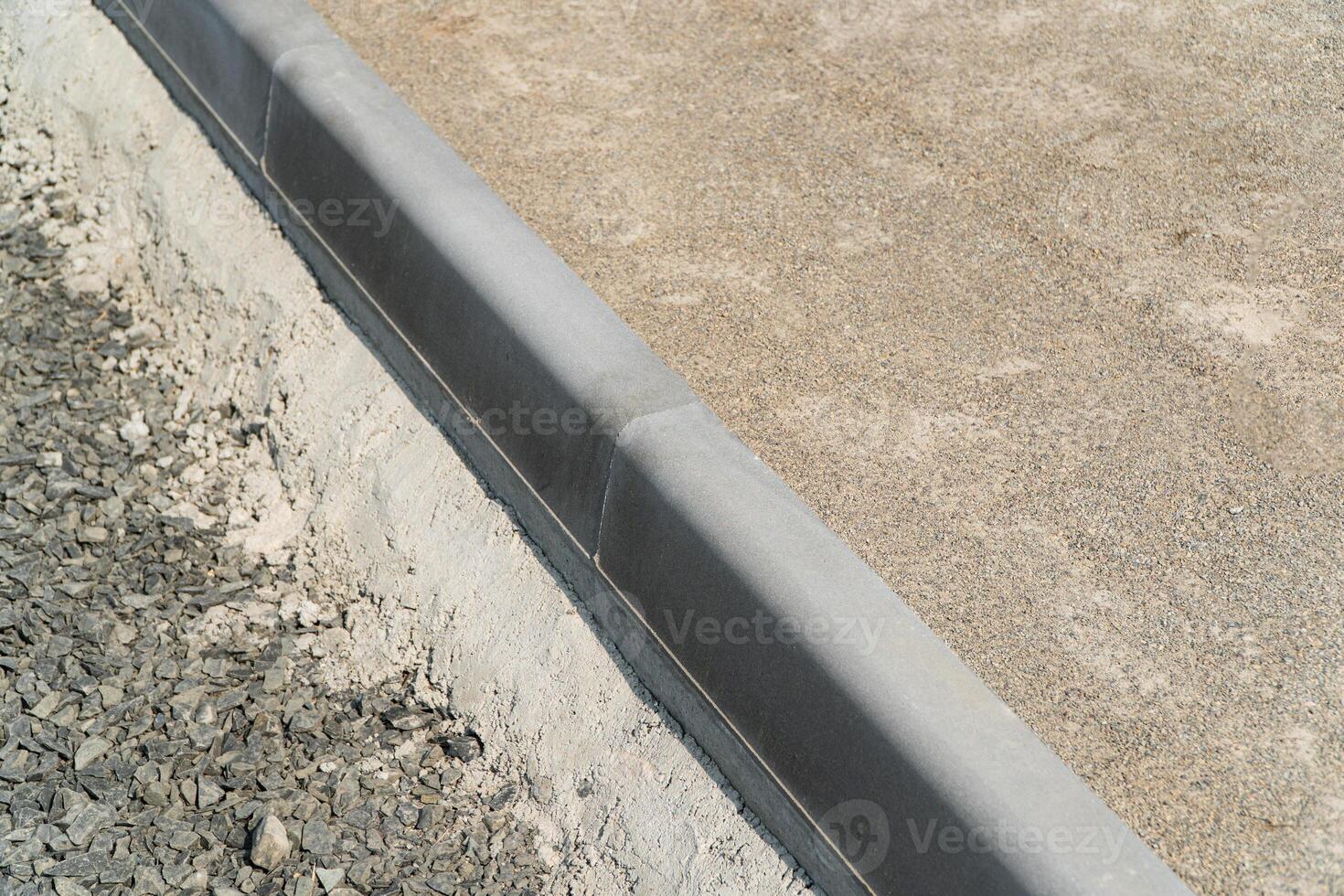 Laying the path with paving bricks. Curb stone. Construction of pedestrian roads photo