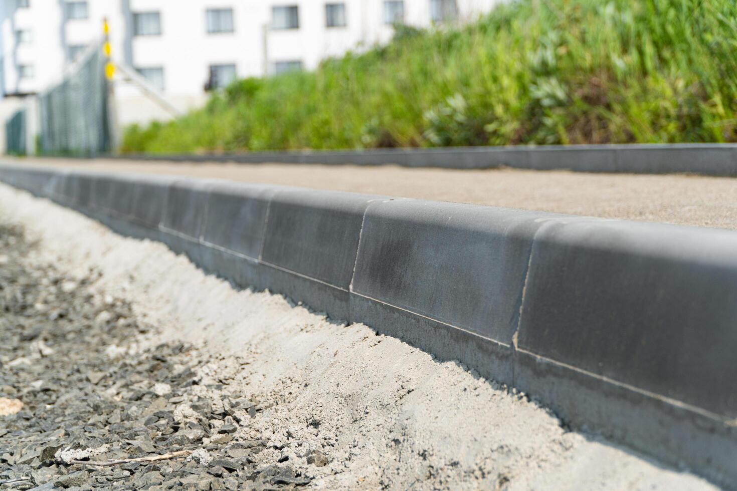Construction of a pedestrian path. Paving of pedestrian paths on city streets. Road curbs and sidewalks. New curbs close up. Curbs detail. Soft focus photo