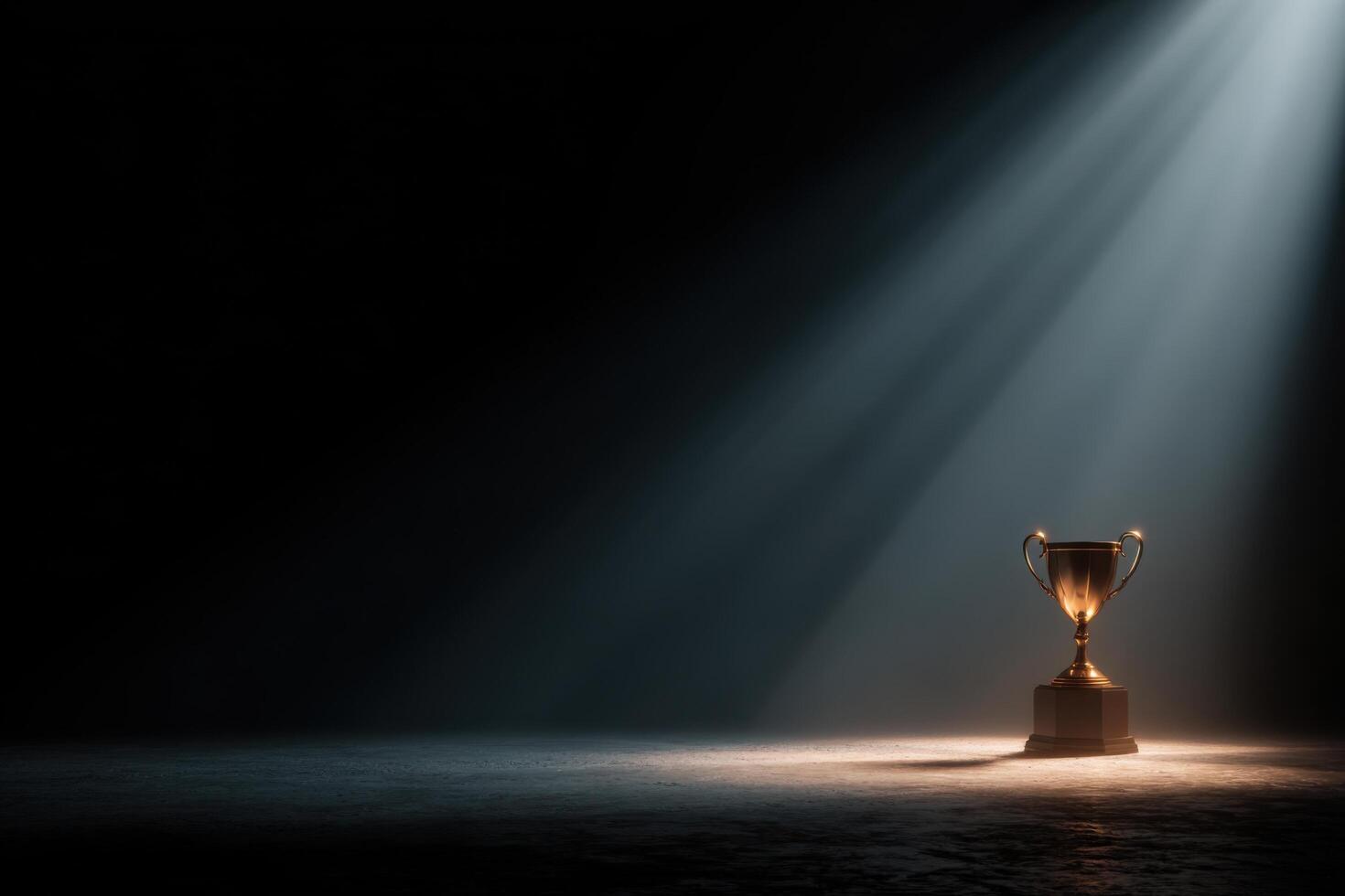 A trophy cup on a dark stage with light coming from the top photo