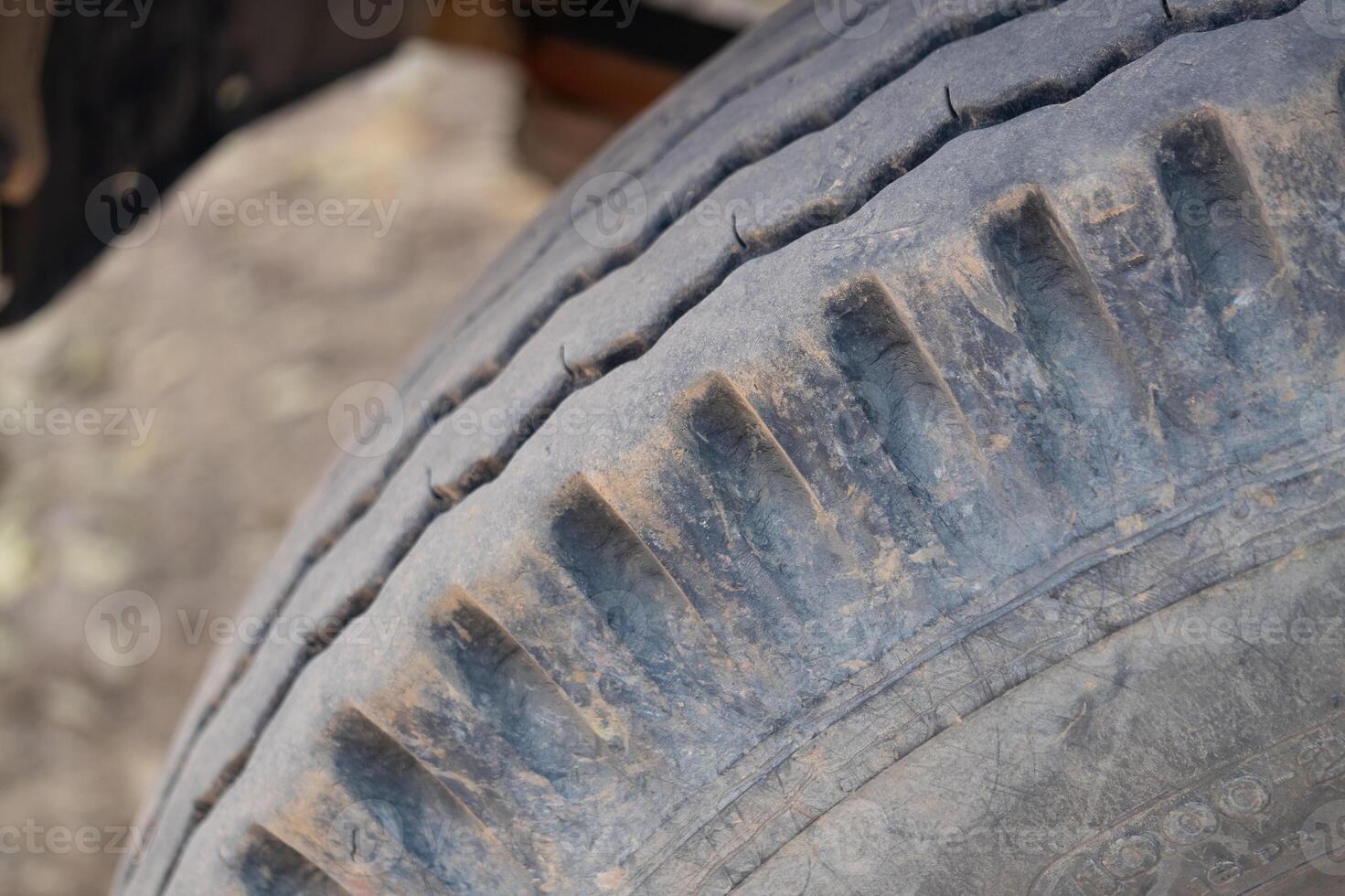 Inspecting worn tire tread vehicle workshop close-up image industrial setting ground level maintenance awareness photo