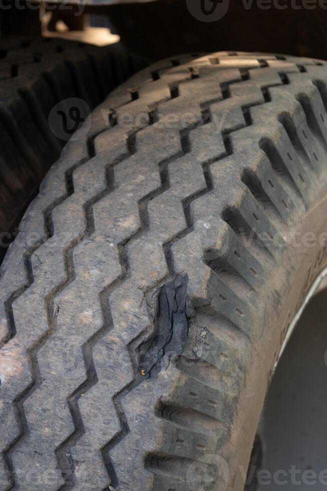 Inspecting worn tire garage vehicle maintenance indoor close-up safety awareness photo