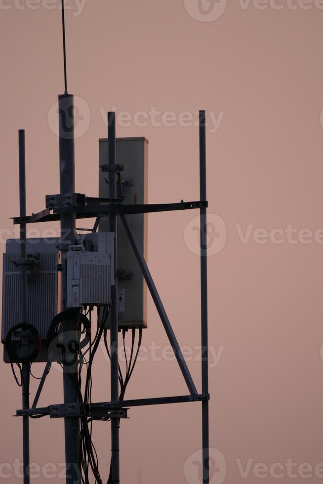 Telecommunication tower installation urban setting photography dusk light elevated view connectivity infrastructure photo