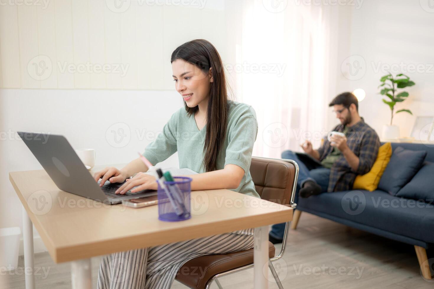 Portrait of a young freelancer smiling while working online via laptop at home with his boyfriend,277 photo