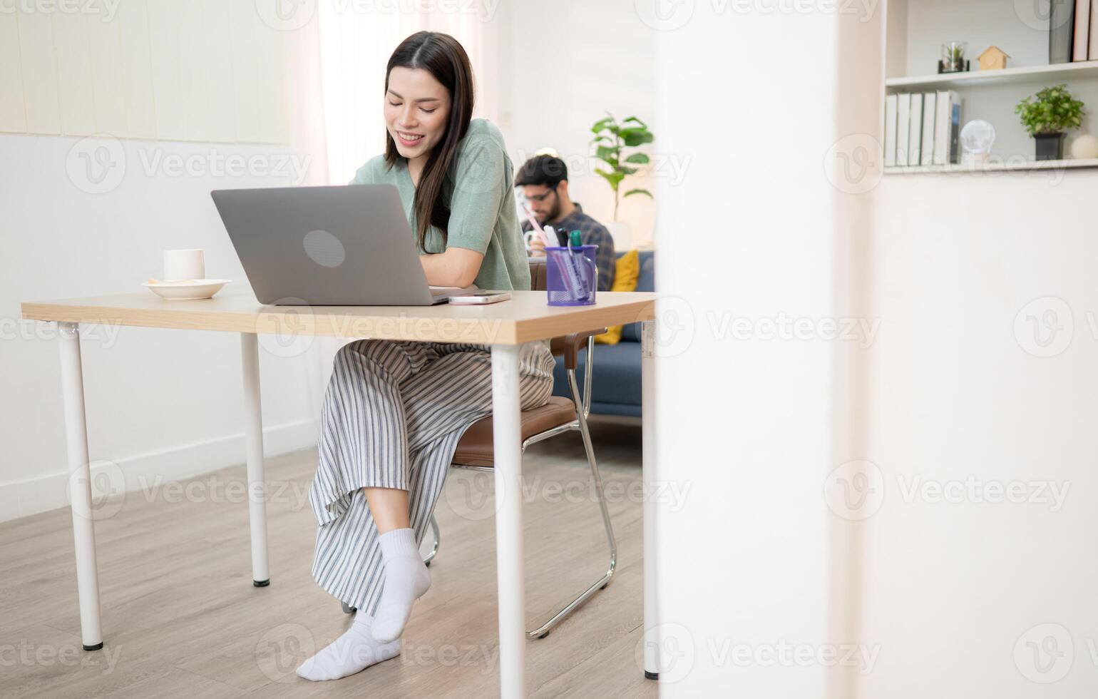 Portrait of a young freelancer smiling while working online via laptop at home with his boyfriend,237 photo