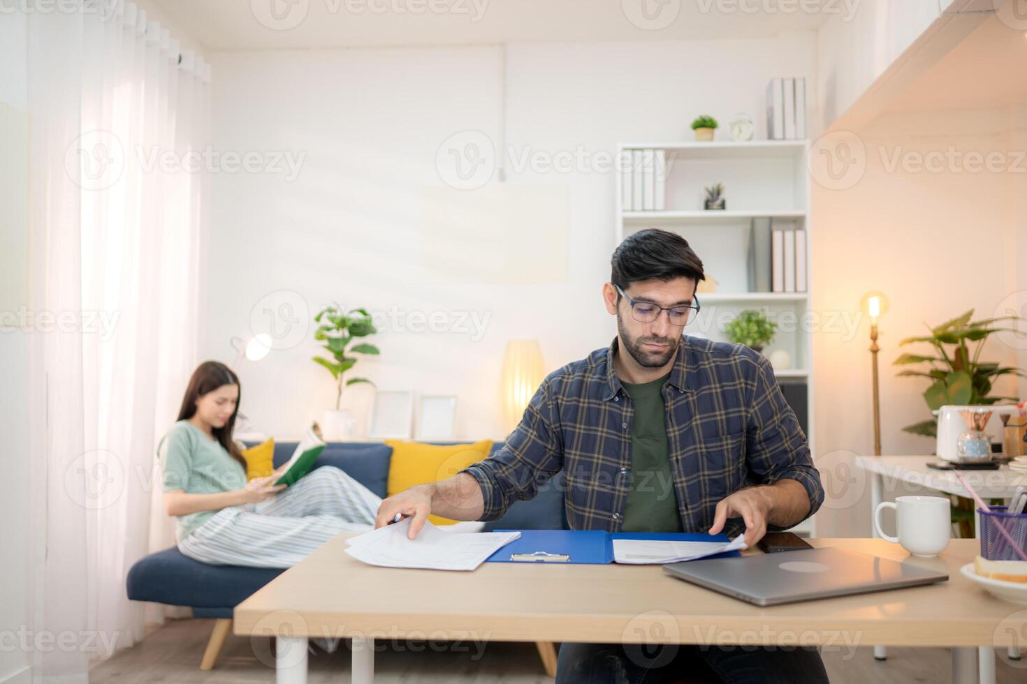 Portrait of a young freelancer smiling while working online via laptop at home with his girlfriend,230 photo