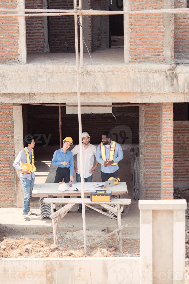 Group of architects and engineers work together to assess the residential home construction site's progress,204 photo