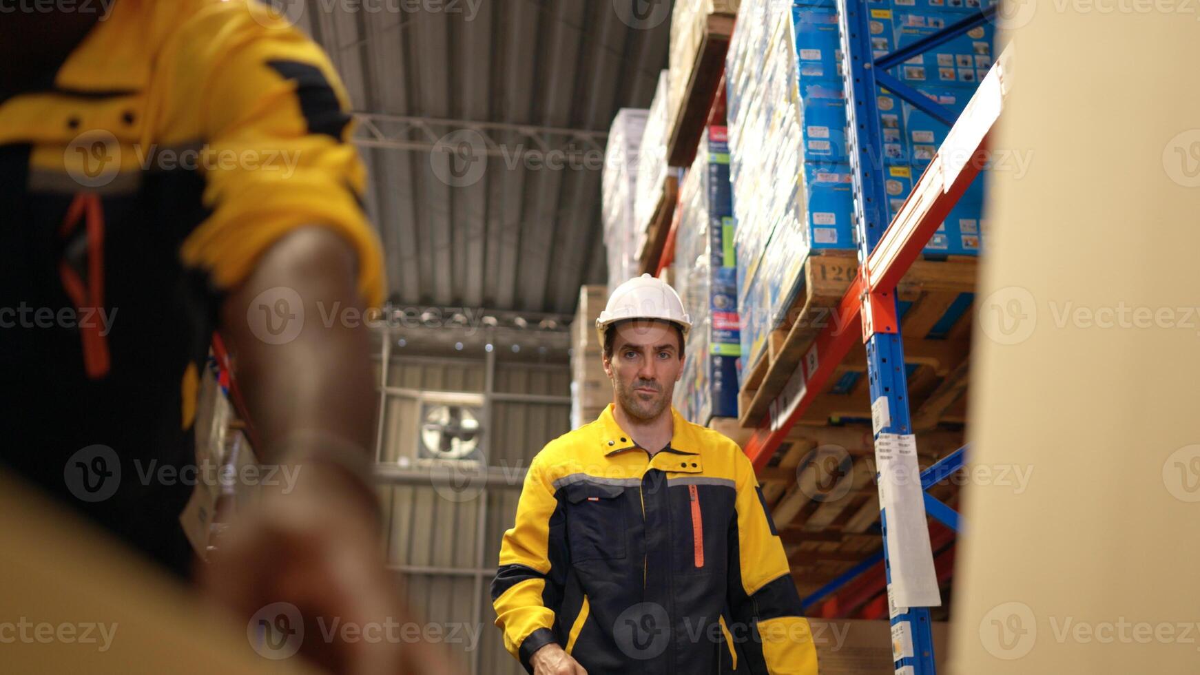 Two warehouse workers are lifting boxes of merchandise on a pallet jack to store on a shelf in a warehouse,152 photo