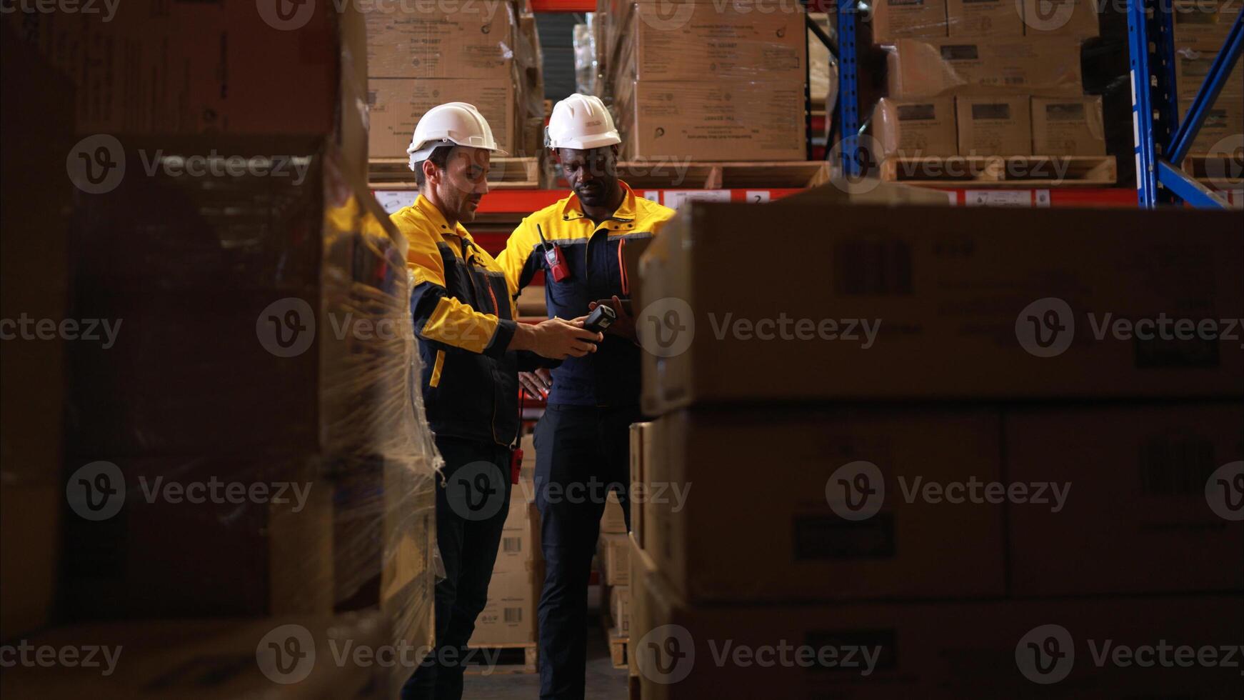 Two warehouse workers are reviewing the list of items based on the documentation,140 photo
