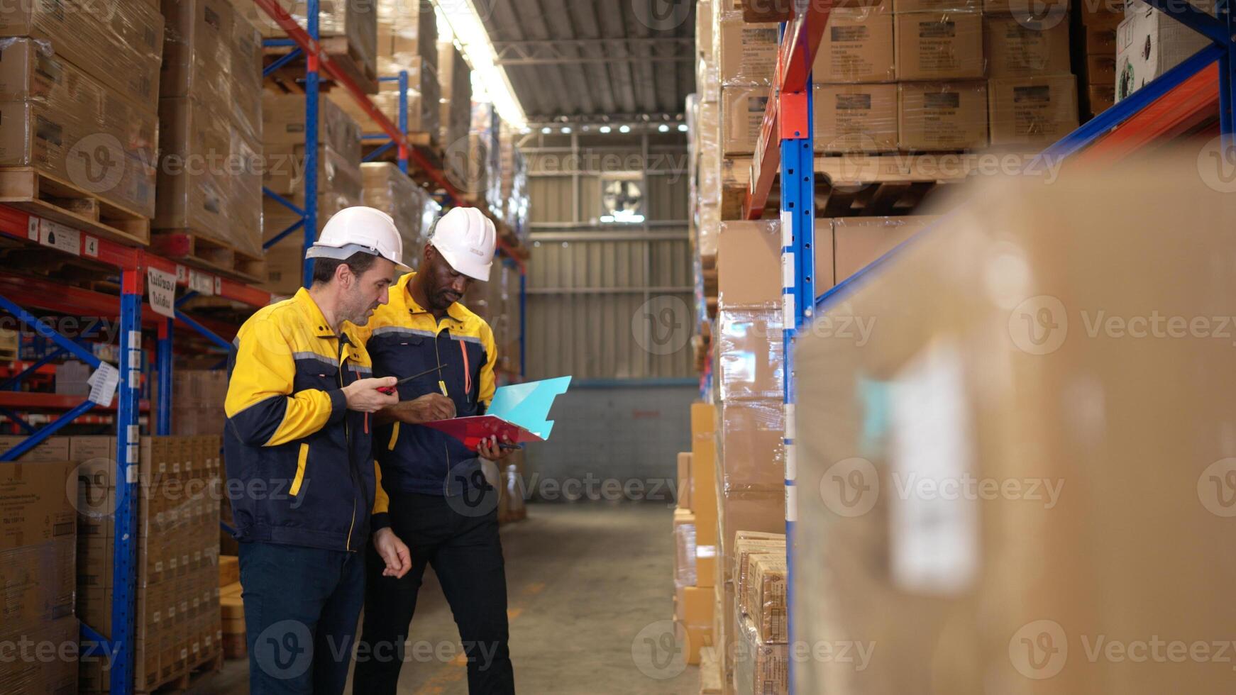 Two warehouse workers are reviewing the list of items based on the documentation,132 photo