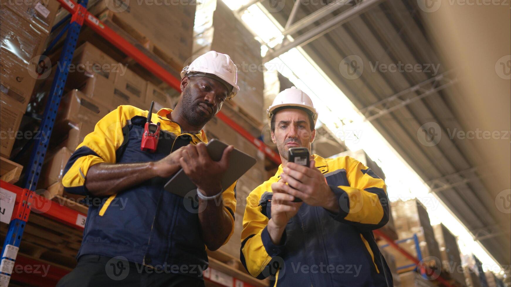 Two warehouse workers are reviewing the list of items based on the documentation,112 photo