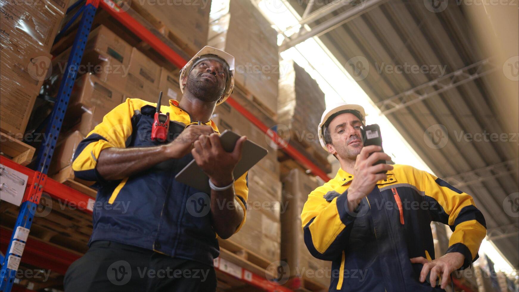 Two warehouse workers are reviewing the list of items based on the documentation,87 photo