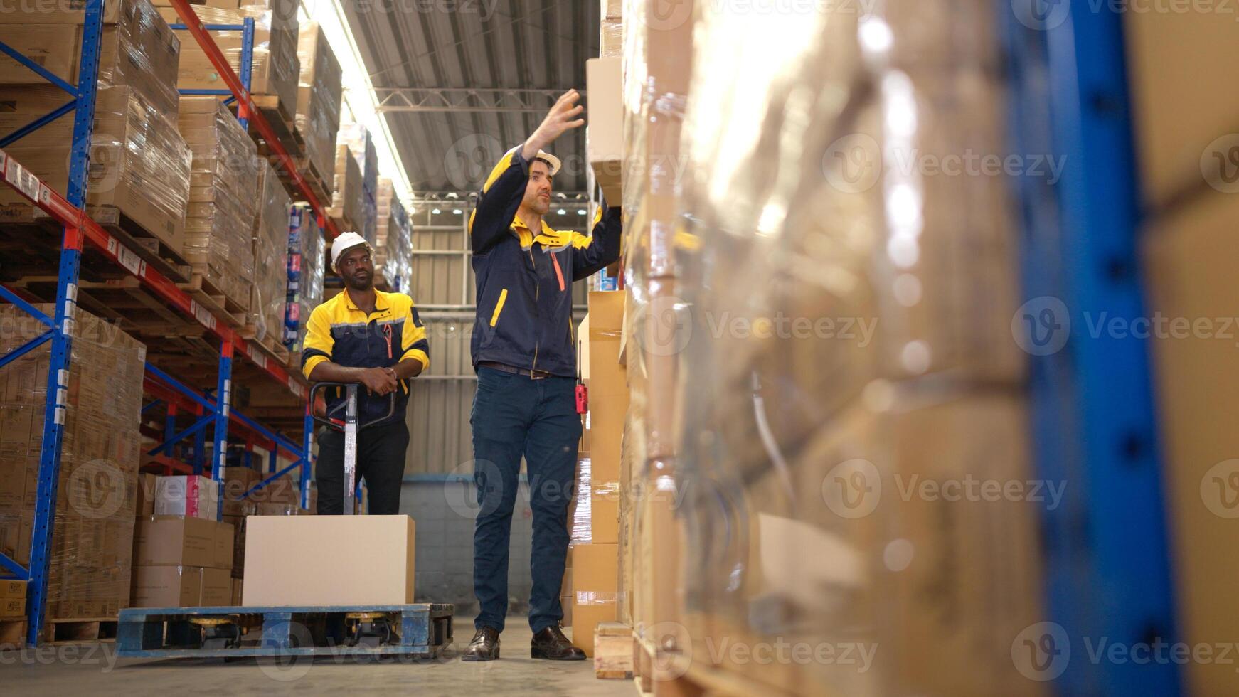 Two warehouse workers are lifting boxes of merchandise on a pallet jack to store on a shelf in a warehouse,72 photo