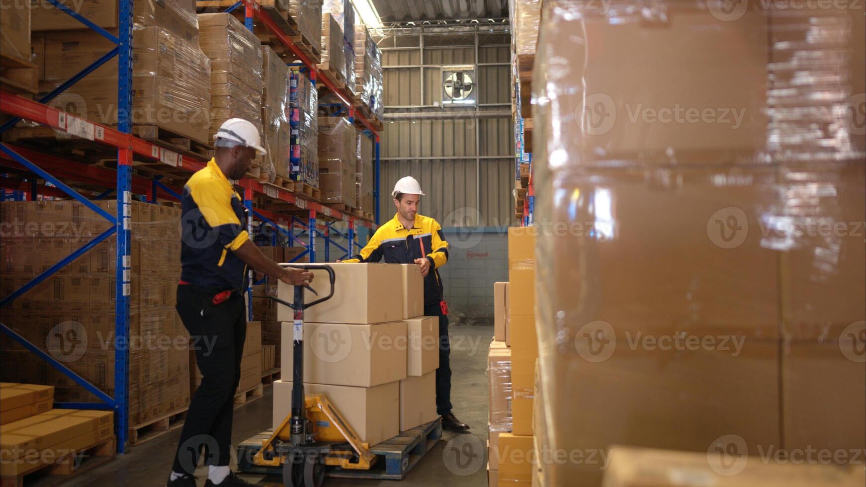 Two warehouse workers are lifting boxes of merchandise on a pallet jack to store on a shelf in a warehouse,68 photo