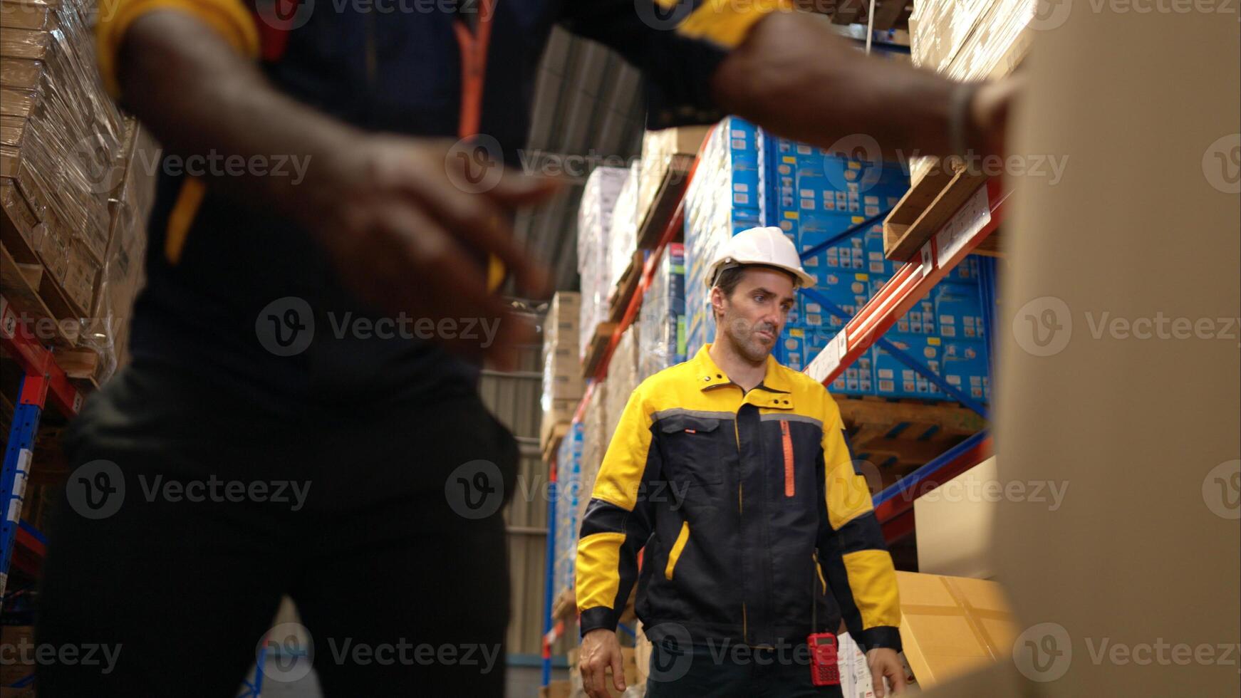 Two warehouse workers are lifting boxes of merchandise on a pallet jack to store on a shelf in a warehouse,61 photo