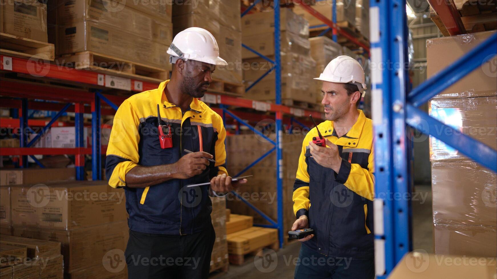 Two warehouse workers are reviewing the list of items based on the documentation,23 photo