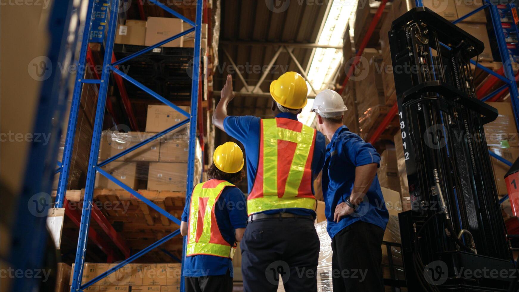 A bunch of warehouse workers are reviewing the list of items based on the documentation,11 photo