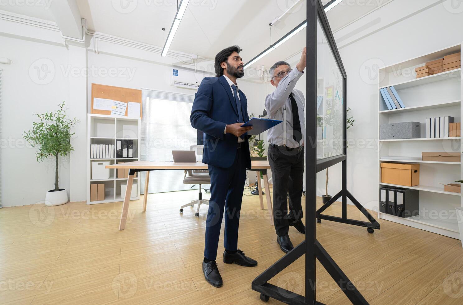 In a contemporary office, two senior executives with a mission to brainstorm and monitor,66 photo