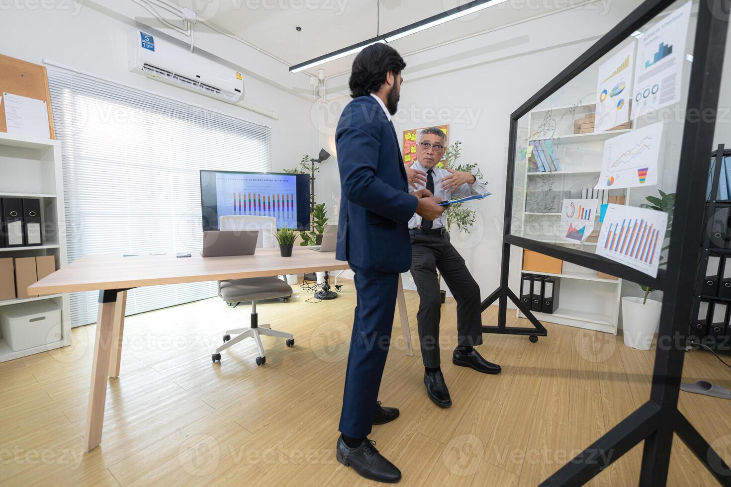 In a contemporary office, two senior executives with a mission to brainstorm and monitor,51 photo