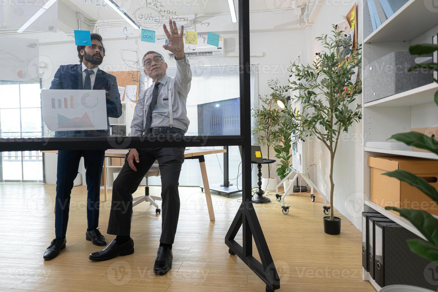 In a contemporary office, two senior executives with a mission to brainstorm and monitor,44 photo