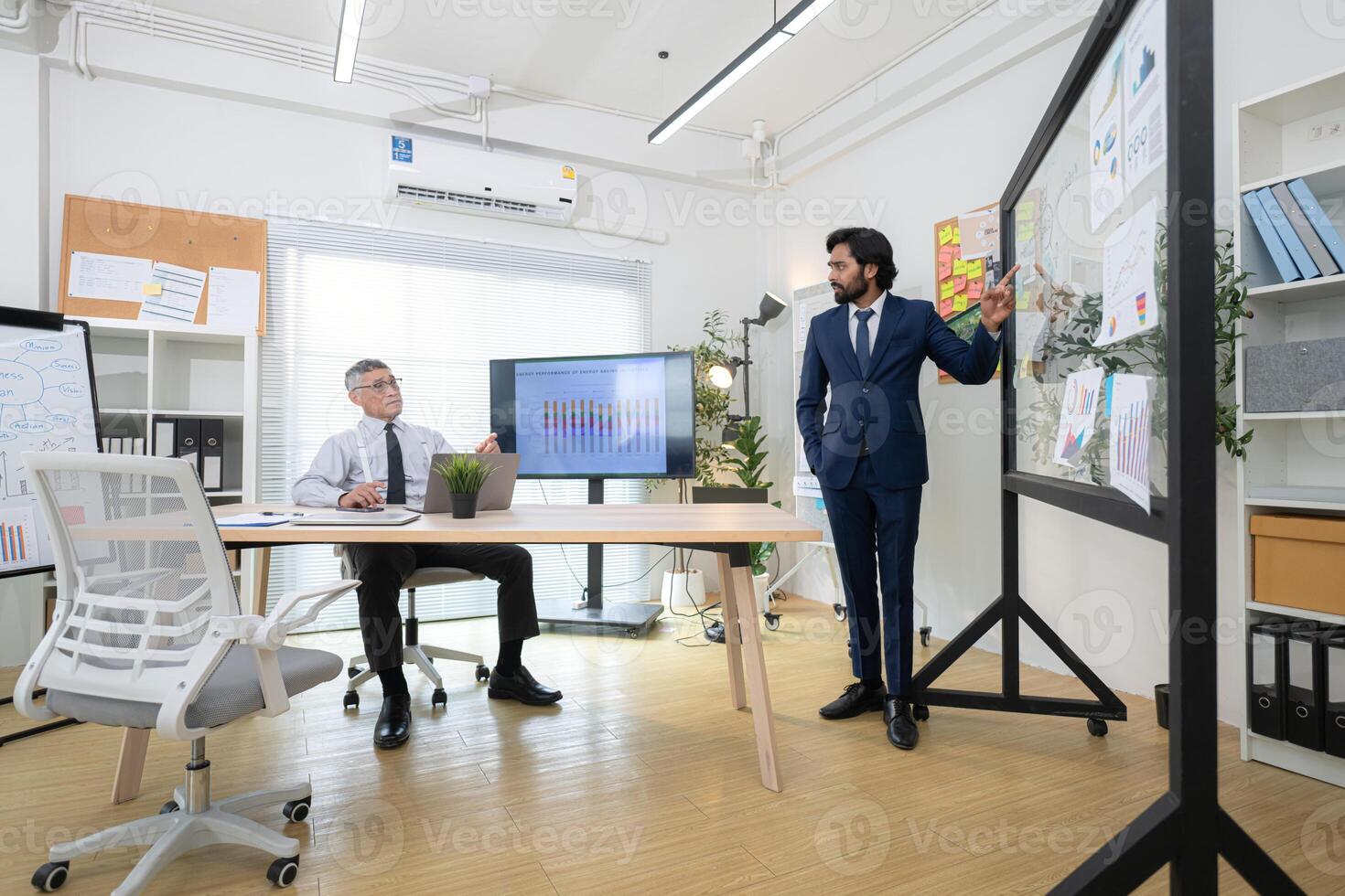In a contemporary office, two senior executives with a mission to brainstorm and monitor,43 photo
