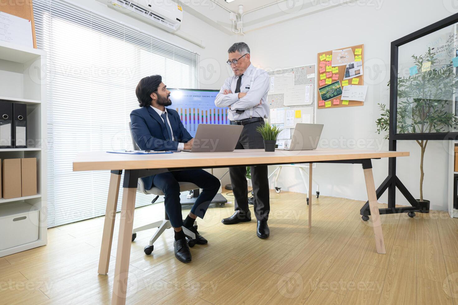 In a contemporary office, two senior executives with a mission to brainstorm and monitor,39 photo