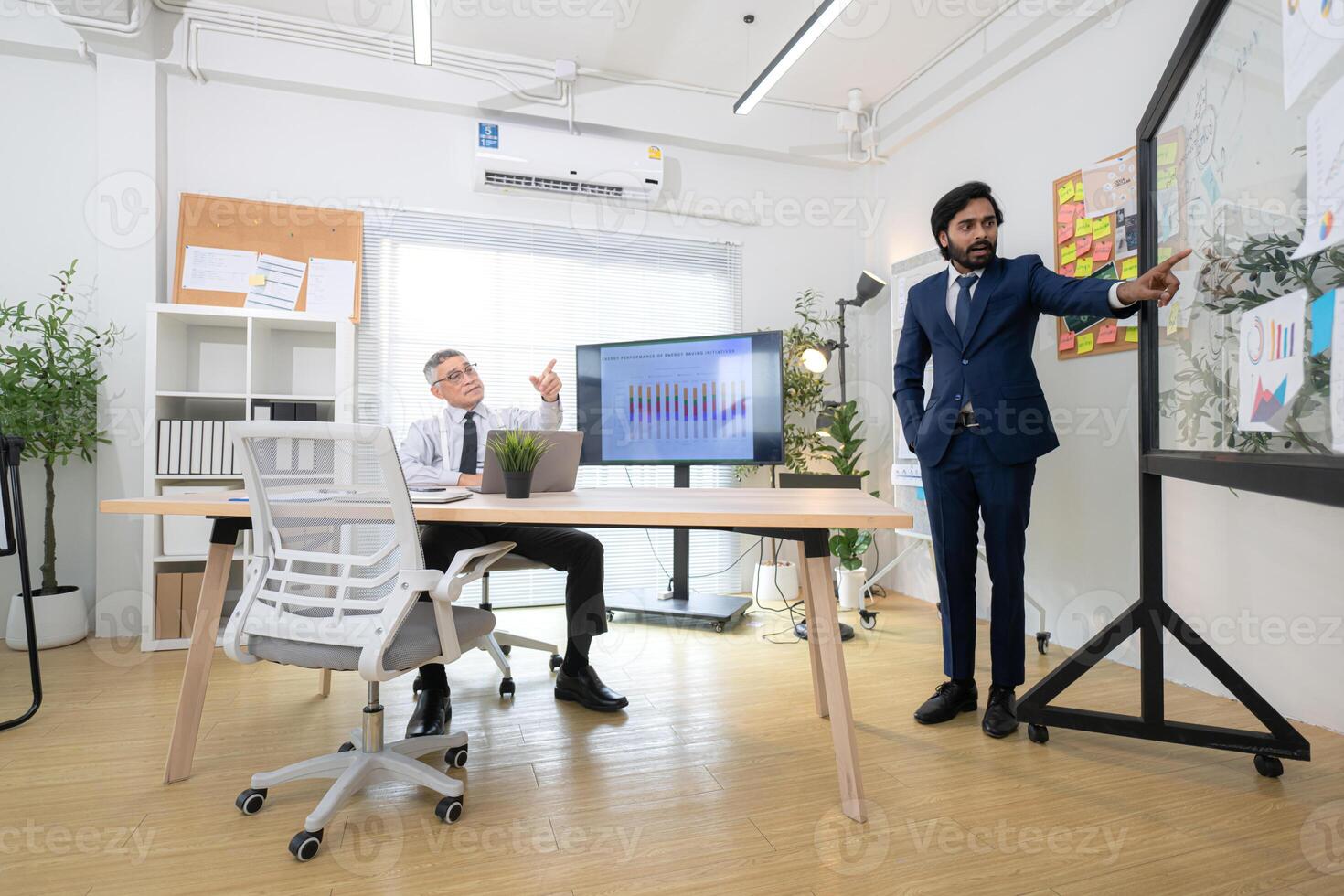 In a contemporary office, two senior executives with a mission to brainstorm and monitor,36 photo