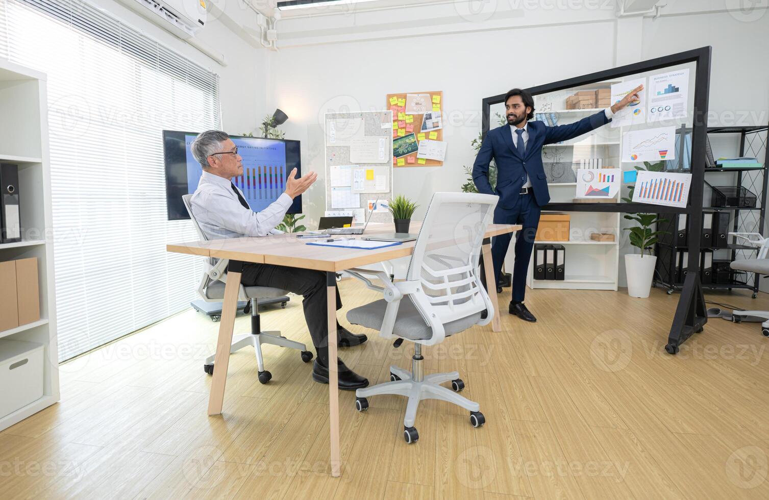 In a contemporary office, two senior executives with a mission to brainstorm and monitor,22 photo